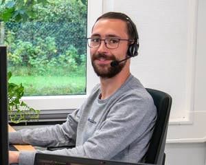 Mann mit Headset im Büro telefoniert